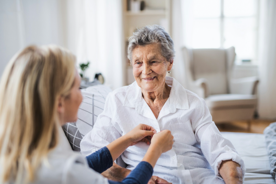 Caregiver assisting elderly woman at home, illustrating IHSS personal care services in Colorado