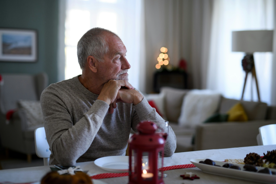 Elderly man sitting alone at home, reflecting signs of loneliness and social isolation